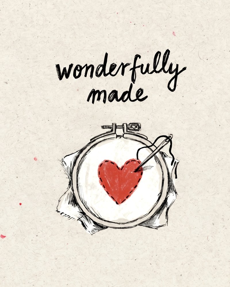 An embroidery hoop with a half-stitched red heart.